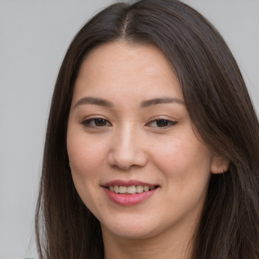 Joyful asian young-adult female with long  brown hair and brown eyes