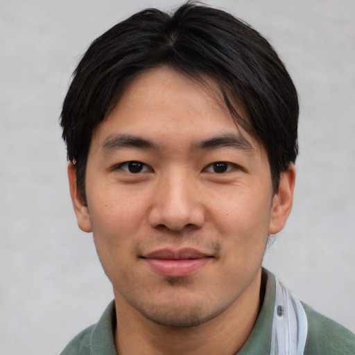 Joyful asian young-adult male with short  brown hair and brown eyes