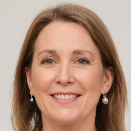 Joyful white adult female with long  brown hair and grey eyes