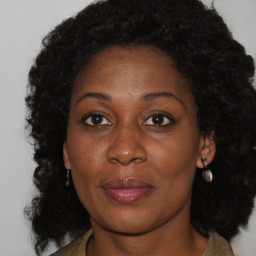 Joyful black adult female with long  brown hair and brown eyes
