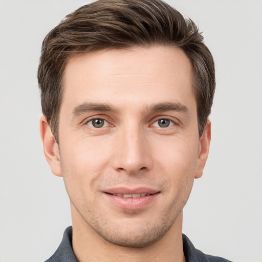 Joyful white young-adult male with short  brown hair and grey eyes