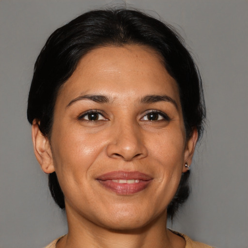 Joyful latino adult female with medium  brown hair and brown eyes