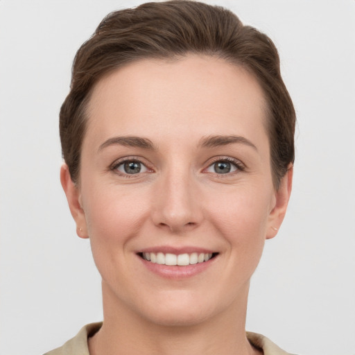 Joyful white young-adult female with short  brown hair and grey eyes