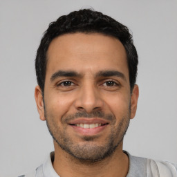 Joyful latino young-adult male with short  black hair and brown eyes