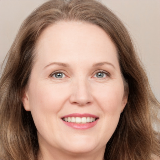 Joyful white adult female with long  brown hair and grey eyes