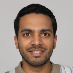 Joyful latino young-adult male with short  black hair and brown eyes