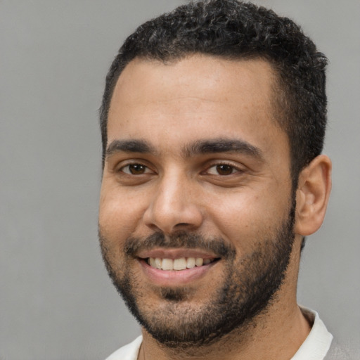 Joyful black young-adult male with short  black hair and brown eyes