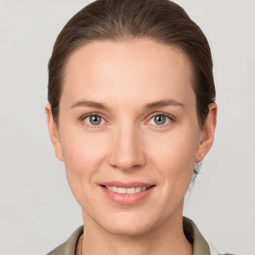 Joyful white young-adult female with medium  brown hair and grey eyes