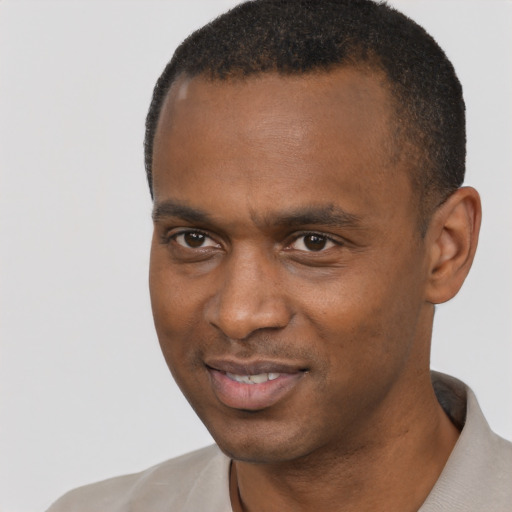 Joyful black young-adult male with short  black hair and brown eyes