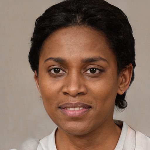 Joyful black young-adult female with short  black hair and brown eyes