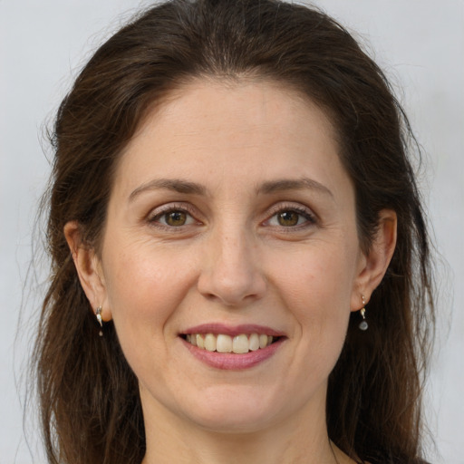 Joyful white adult female with long  brown hair and brown eyes