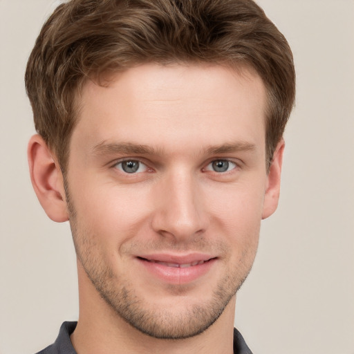 Joyful white young-adult male with short  brown hair and grey eyes