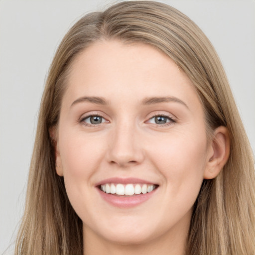 Joyful white young-adult female with long  brown hair and blue eyes