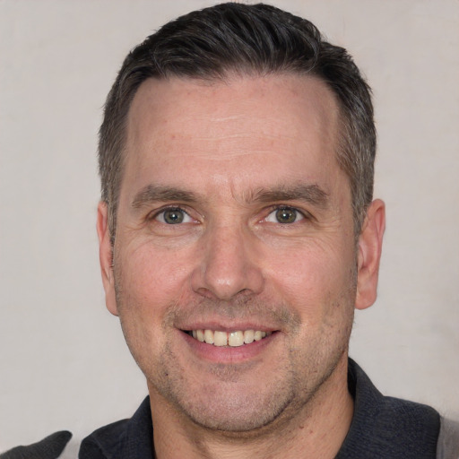 Joyful white adult male with short  brown hair and brown eyes