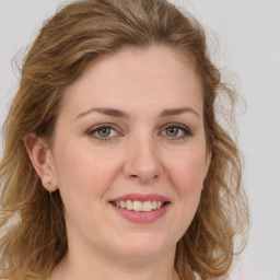 Joyful white young-adult female with long  brown hair and green eyes