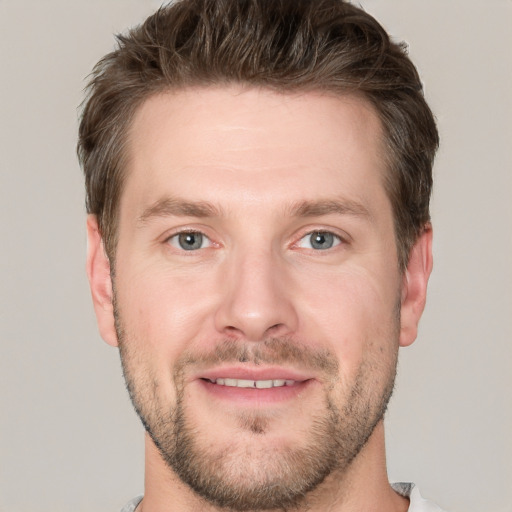 Joyful white young-adult male with short  brown hair and grey eyes