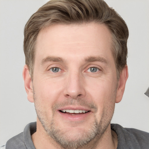 Joyful white adult male with short  brown hair and grey eyes