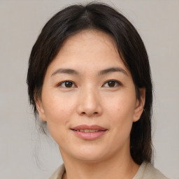 Joyful asian young-adult female with medium  brown hair and brown eyes