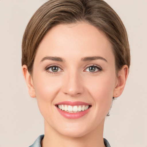 Joyful white young-adult female with short  brown hair and grey eyes