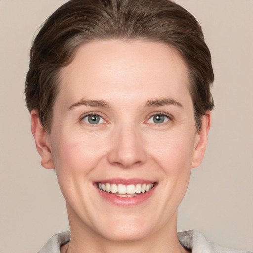 Joyful white young-adult female with short  brown hair and grey eyes