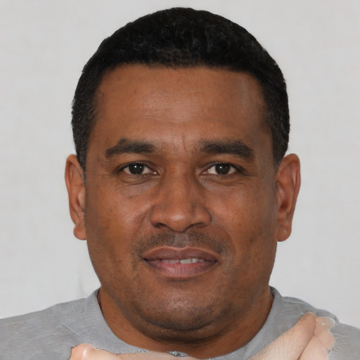 Joyful black adult male with short  black hair and brown eyes