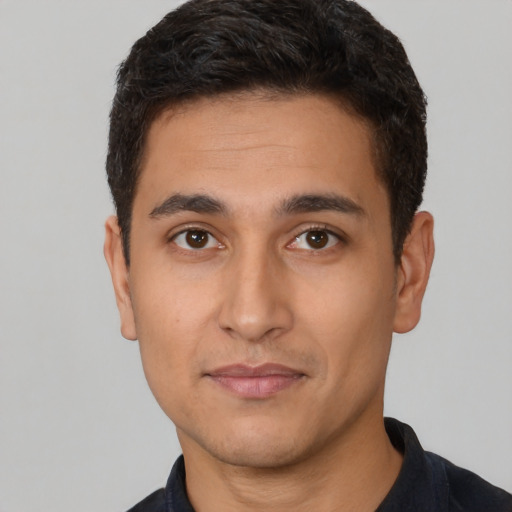 Joyful latino young-adult male with short  brown hair and brown eyes