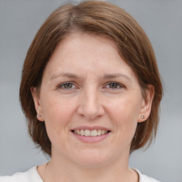 Joyful white adult female with medium  brown hair and grey eyes