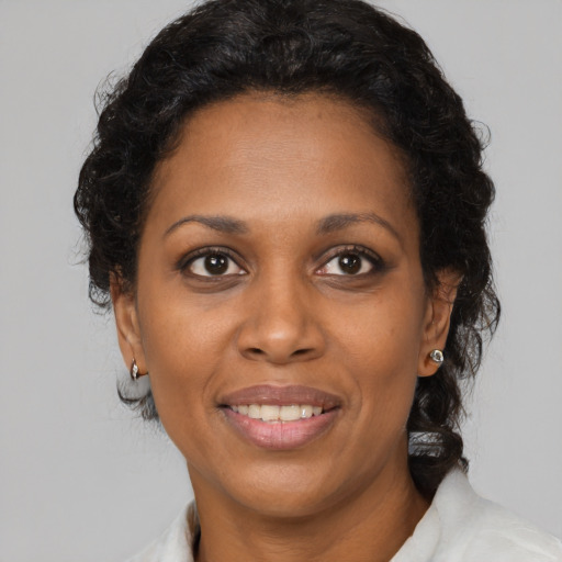 Joyful black adult female with medium  brown hair and brown eyes