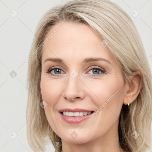 Joyful white young-adult female with long  brown hair and blue eyes