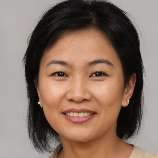 Joyful asian young-adult female with medium  brown hair and brown eyes