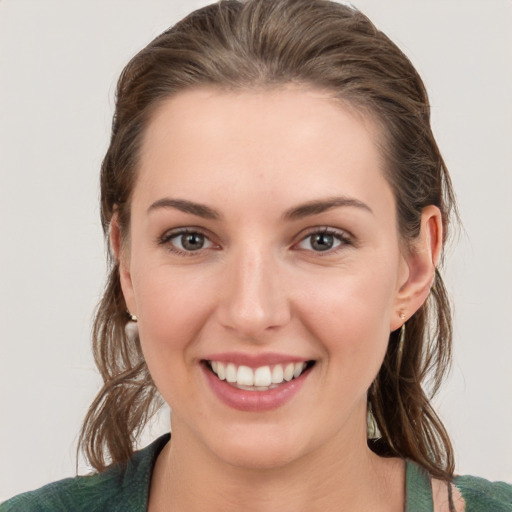 Joyful white young-adult female with medium  brown hair and grey eyes