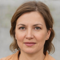 Joyful white adult female with medium  brown hair and grey eyes