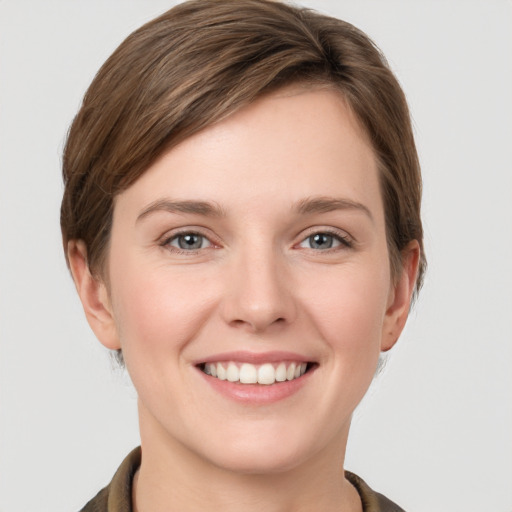 Joyful white young-adult female with short  brown hair and grey eyes