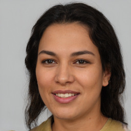 Joyful latino young-adult female with medium  brown hair and brown eyes