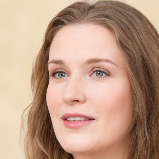 Joyful white young-adult female with long  brown hair and blue eyes