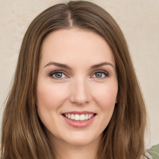 Joyful white young-adult female with long  brown hair and green eyes