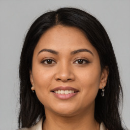 Joyful latino young-adult female with long  brown hair and brown eyes