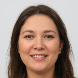 Joyful white young-adult female with long  brown hair and brown eyes