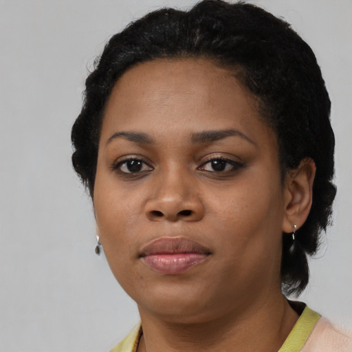 Joyful black young-adult female with short  black hair and brown eyes