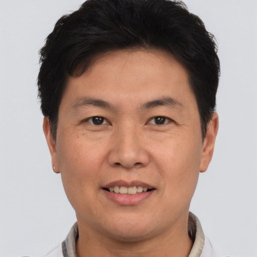 Joyful asian adult male with short  brown hair and brown eyes