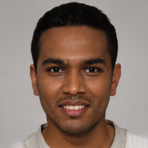Joyful black young-adult male with short  black hair and brown eyes