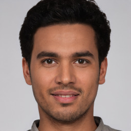 Joyful white young-adult male with short  black hair and brown eyes