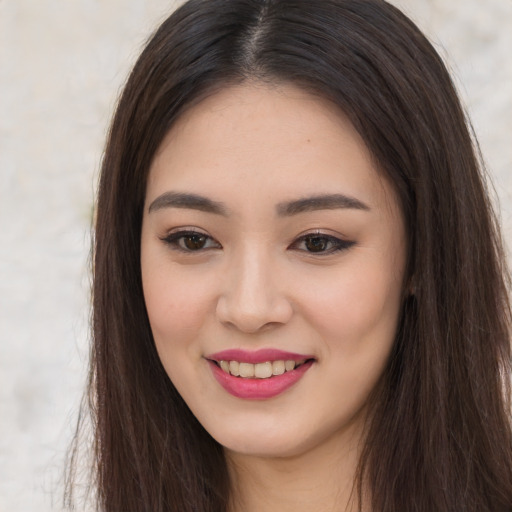 Joyful asian young-adult female with long  brown hair and brown eyes