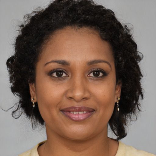 Joyful black young-adult female with medium  brown hair and brown eyes