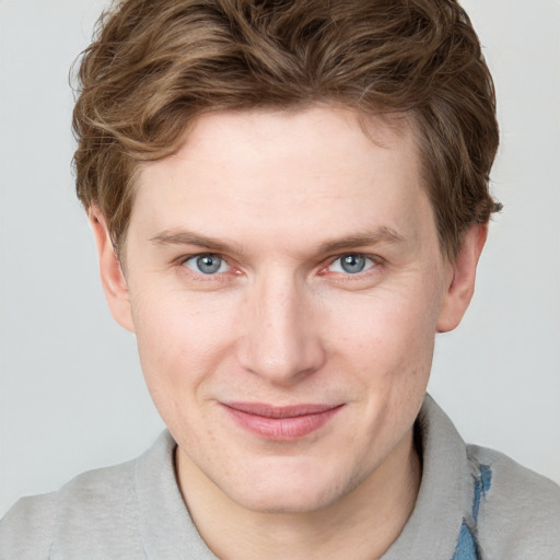 Joyful white young-adult male with short  brown hair and blue eyes