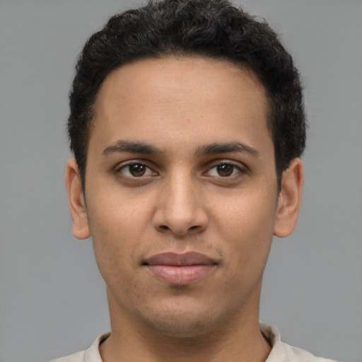 Joyful latino young-adult male with short  brown hair and brown eyes
