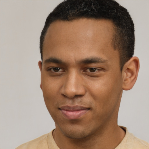 Joyful black young-adult male with short  black hair and brown eyes