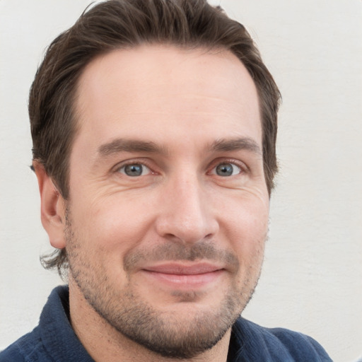 Joyful white adult male with short  brown hair and grey eyes