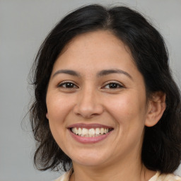 Joyful latino young-adult female with medium  brown hair and brown eyes