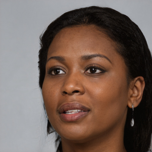 Joyful black young-adult female with long  black hair and brown eyes